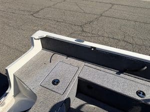 Close-up of boat deck with storage hatch and Mercury 60HP outboard motor.