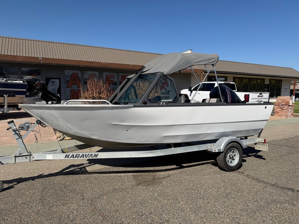 Small white boat with canopy on trailer at ASFB Marine dealership.