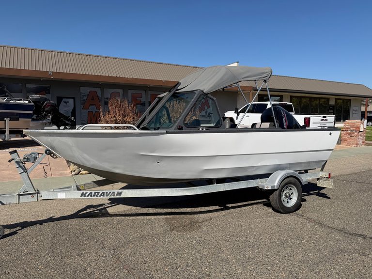 Small white boat with canopy on trailer at ASFB Marine dealership.