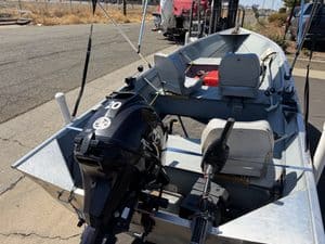 Aluminum fishing boat with outboard motor and seating for two.
