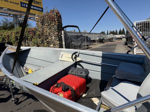 Aluminum boat with red fuel tank and equipment at marina.
