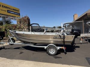 Klamath 15FT Advantage boat on trailer with outboard motor.