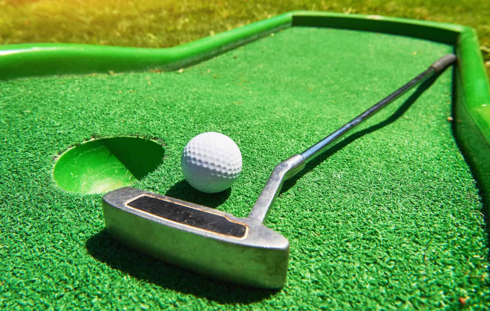 Miniature golf club and ball on green course at Bat'n Club.