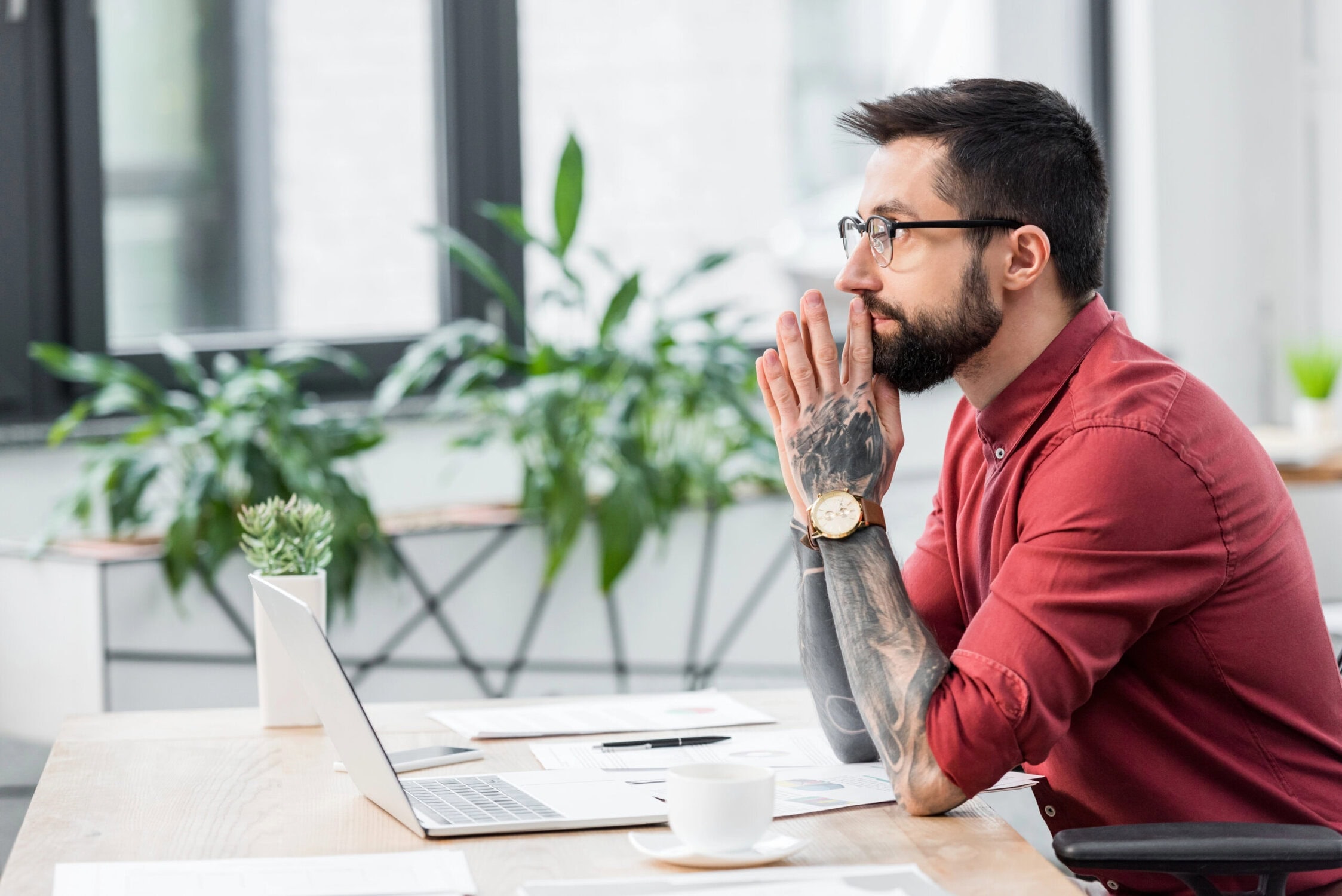 Man sat at his desk touching his chin
