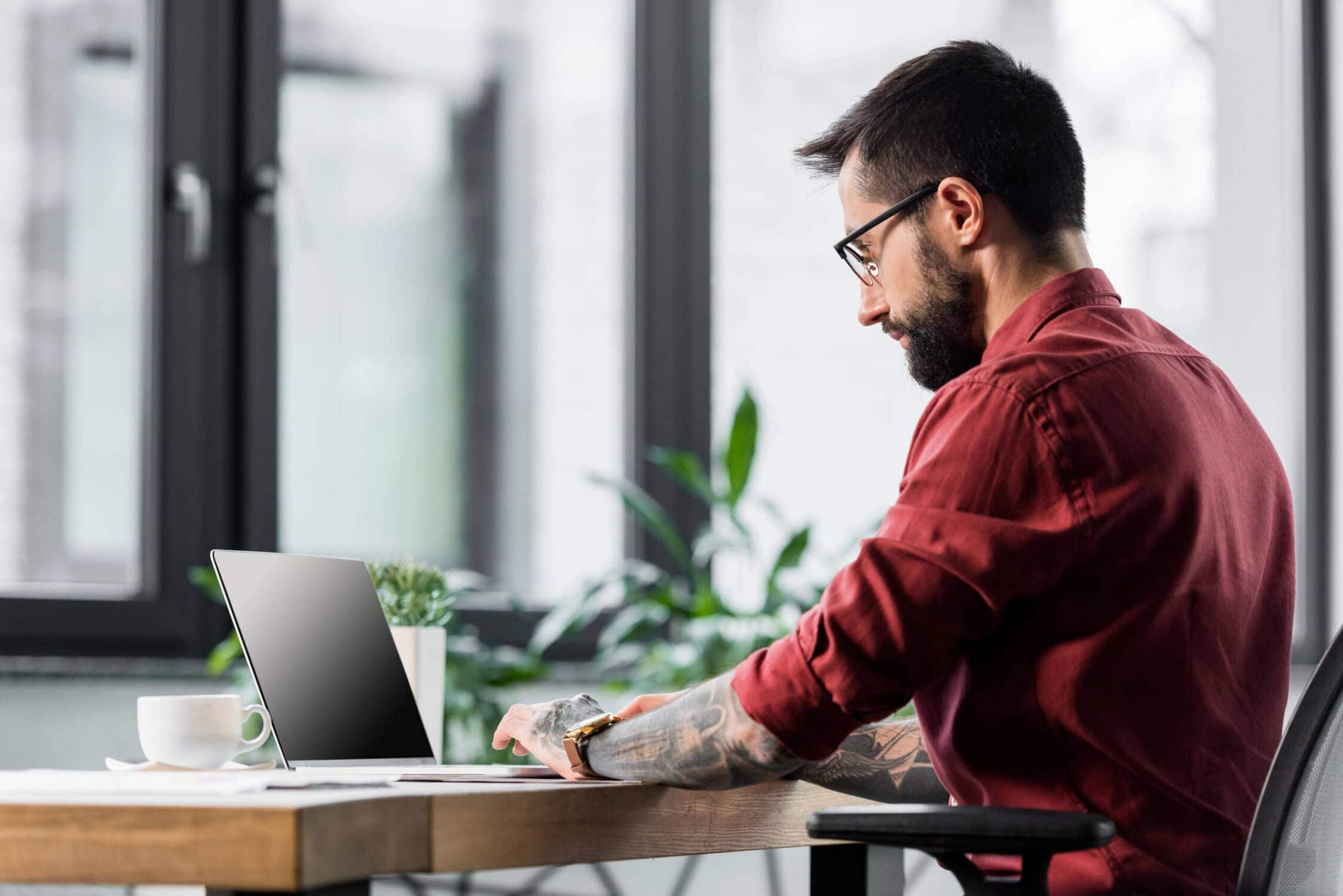 man sat at desk looking at computer