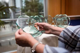 A pair of hands holding a prize for the TES Awards during the Leaders for a Day in Brussels