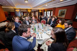 A group of people sitting on a table during a lunch event featuring Roberto Viola in Brussels