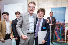 Pascal Smet laughs and hugs a student during the Sci Tech Challenge ceremony event in Brussels