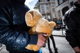 Close up flash street photograph of man carrying a teddy bear in Brussels