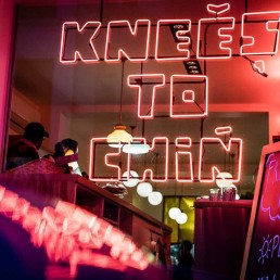 Neon lights in the front window of Knees to Chin restaurant in Sainte-Catherine, Brussels
