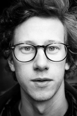 Black and white closeup portrait of a man with glasses from Belgium taken in Brussels