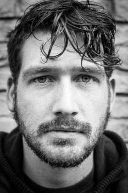 Black and white closeup portrait of a man with beard from France taken in Brussels