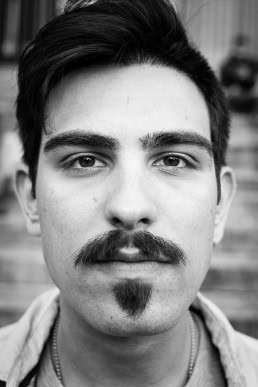 Black and white closeup portrait of a man with a moustache from Italy taken in Brussels