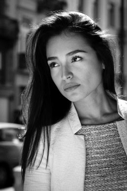 Black and white portrait of a dark-haired woman looking away under the sunlight