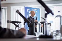 A speaker seen through several microphones during a conference for EURADA in Brussels