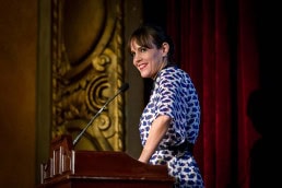 A woman speaker smiles while addressing the audience during a Gala dinner event in Brussels