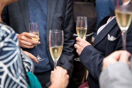 A closeup of cava glasses raised by guests during a dinner event at Hispania, Brussels