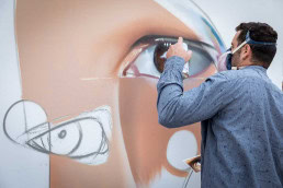 A graffiti artist working on a piece with sprays at the Groenplaats, Antwerp