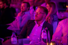 A guest with a concentrated gaze listens to a speaker during a gala dinner event in Brussels