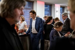A guest talks to other guests during an walking dinner event in Brussels