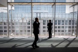 A man walks in front of a window inside the European Parliament in Brussels