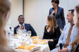 A student laughing as he speaks during a gala dinner event for JA Europe in Brussels