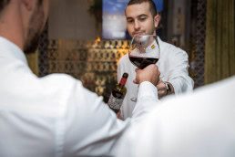 A waiter hands a wine glass to a guess during a dinner event at Hispania, Brussels