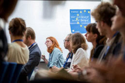 A woman asks a question during a conference meeting for the DAAD in Brussels