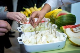 Hands approaching a fruit basket to try them during an event for APEX Brasil in Brussels