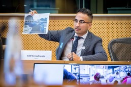 Syed Hasnain, the Network for Refugee Voices, shows a picture during the MCE Conference at the EU Parliament
