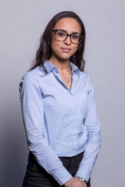 Corporate portrait of a woman wearing a blue shirt and glasses