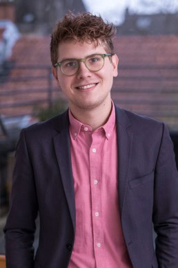 Portrait of a man wearing a pink shirt and a jacket for ECOS in Brussels