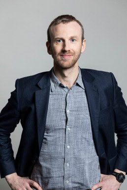 Portrait of a man wearing a blue jacket for the European Social Network