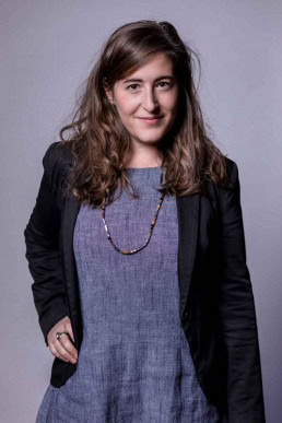 Corporate portrait of a woman smiling wearing a blue dress and jacket