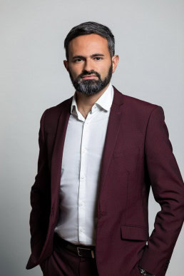 Corporate portrait of a man wearing a red wine color jacket for European Social Network