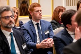 Closeup of a ginger man in the audience listening to a speech during the GC Summit Belgium 2020