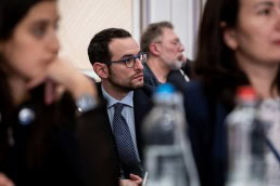 Closeup of an attendee carefully listening to a speech during the 9th meeting of the WGECC in Brussels