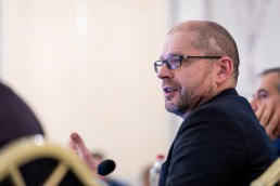 Closeup of a man while speaking wearing glasses during the 9th meeting of the WGECC in Brussels