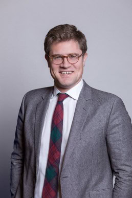 Corporate portrait of a man carrying glasses wearing gray jacket a for Berquin Notarissen in Brussels	