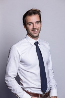 Corporate portrait of a man wearing a white shirt and blue tie for Berquin Notarissen in Brussels	