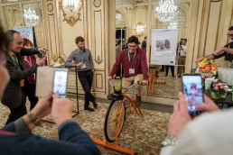 A man rides a static bike to produce a smoothie during an event in Brussels