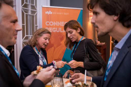 Two women exchange business cards during an event at the Cercle de Lorraine in Brussels
