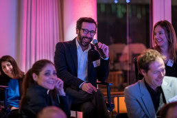 A man from the audience smiles while posing a question during the Netflix Belgium Walking Dinner