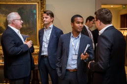 A group of men networking during a coffee break at the Sweetwood Capital annual conference in Brussels