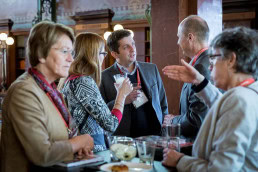 A group of people networking during a coffee break at the Solvay Library in Brussels
