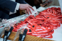 A hand close to a set of lanyards from The Economist during the Patient Value Summit in Brussels