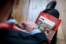 A magazine The Economist seen laying on top of the legs of a attendant during the Patient Value Summit
