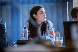 A woman with black hair listens during a conference in Brussels