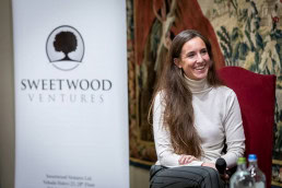 A woman smiles during a discussion panel at the Sweetwood Capital annual meeting in Brussels