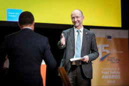 Matthew Baldwin receives a guest on stage during the 2019 Excellence in Road Safety Awards in Brussels